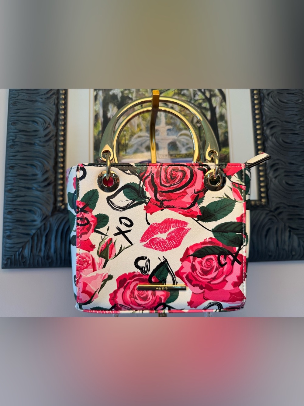 This Aldo "Love Potion" mini satchel features a vibrant white floral print